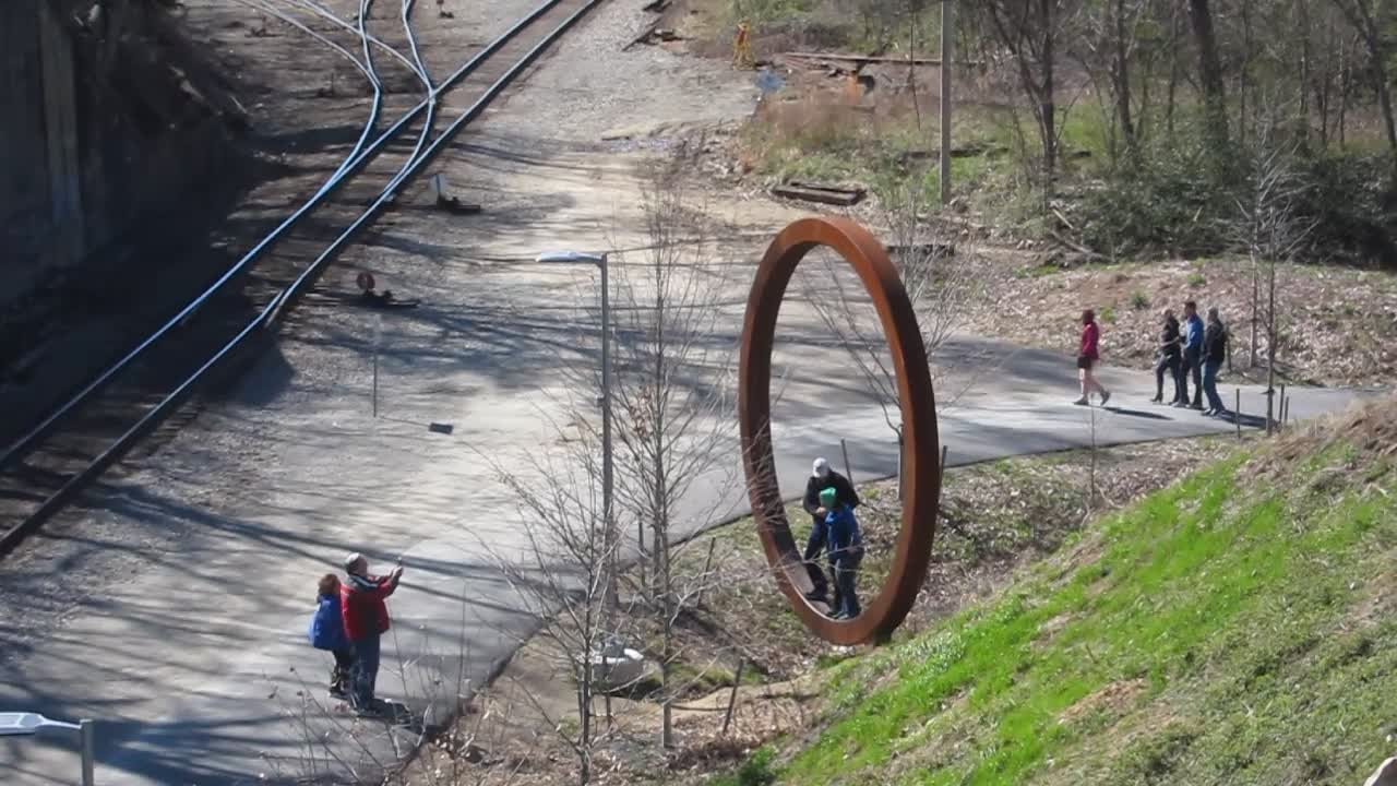 People posing for pics in one of the big copper rings, Manchester